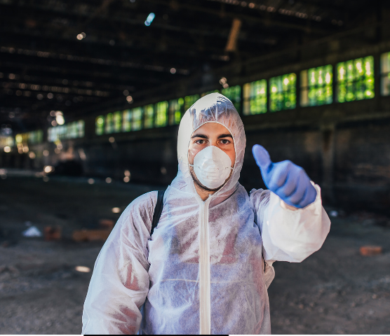 Experte für Schädlingsbekämpfung in Schutzkleidung mit Daumen nach oben nach erfolgreichem Einsatz.
